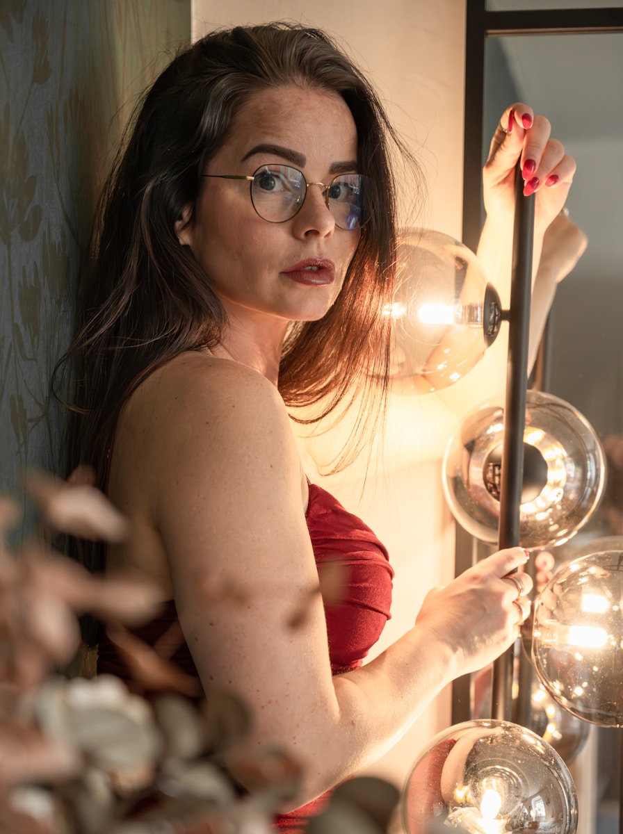 A woman in a red dress looking at herself in a mirror