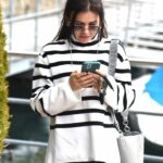 Woman in striped sweater looking at smartphone
