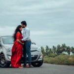 a man and woman standing next to a car
