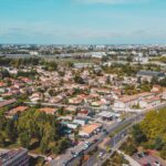 Aerial view of a residential area in Bordeaux, France, featuring houses, roads, and greenery.