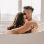 Un moment intime entre un couple dans une baignoire moderne à l'intérieur.